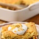 Pinterest pin with a baked cowboy cornbread casserole and serving on a plate topped with sour cream.